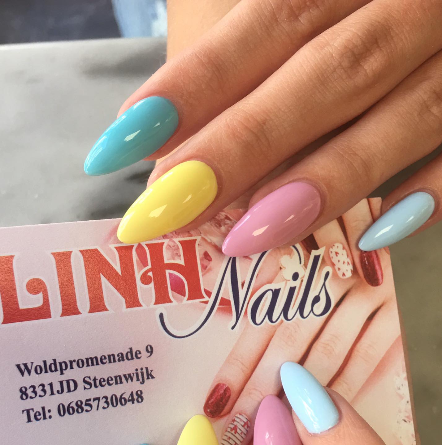 Pastelkleurige amandelnagels met het visitekaartje van Linh Nails