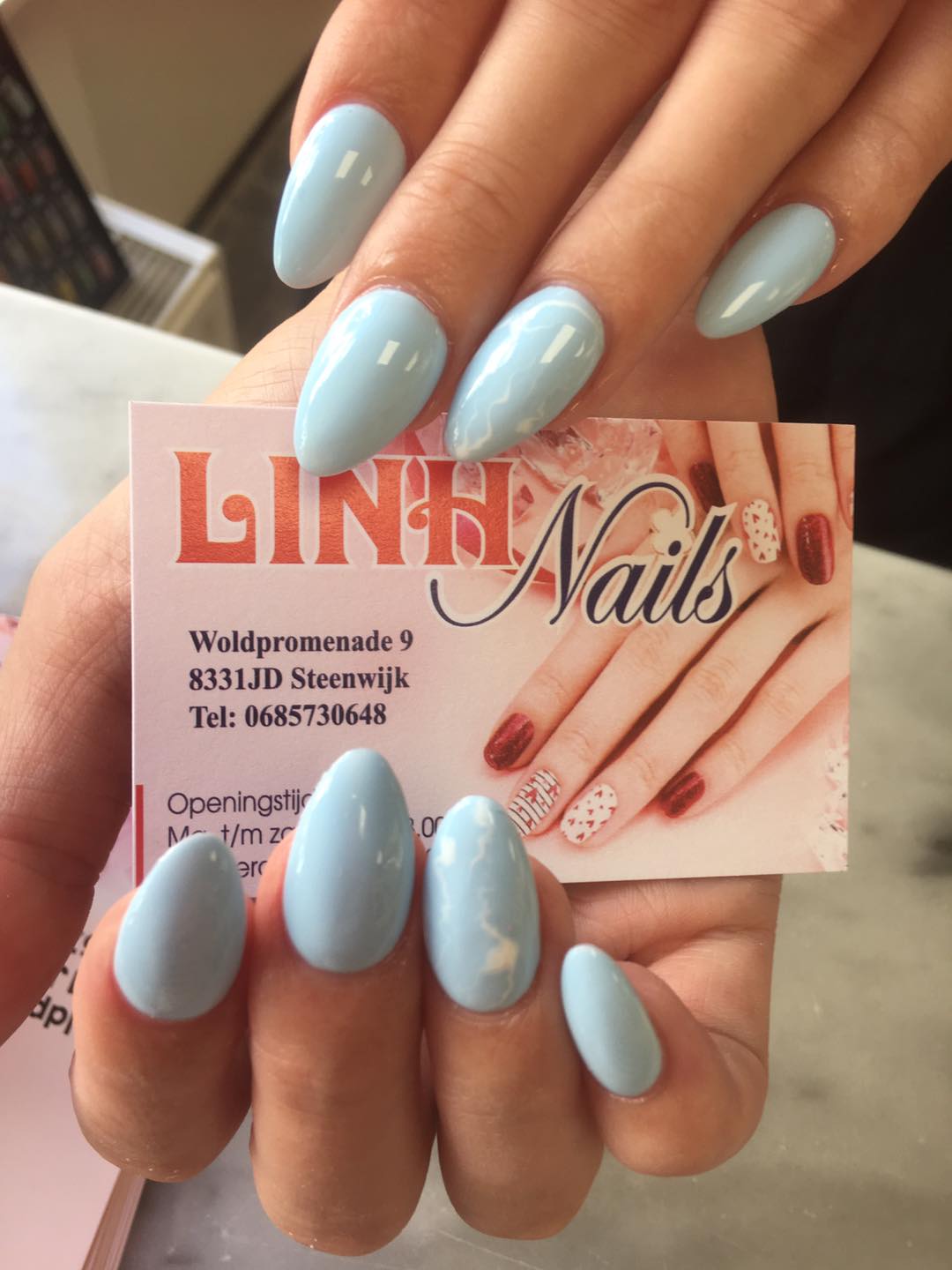 Lichtblauwe amandelnagels met het visitekaartje van Linh Nails